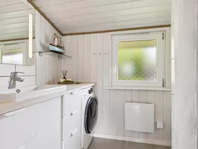 a laundry room with a sink and a washing machine at Holiday Home Marli - 700m from the sea by Interhome in Blokhus
