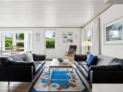 a living room with two couches and a coffee table at Holiday Home Marli - 700m from the sea by Interhome in Blokhus