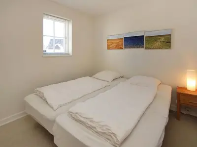two beds in a room with a table and a window at Holiday Home Ønef - 1km from the sea by Interhome in Blokhus