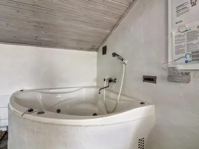 a bath tub in a bathroom with a shower at Holiday Home Yessica - 300m from the sea by Interhome in Løkken