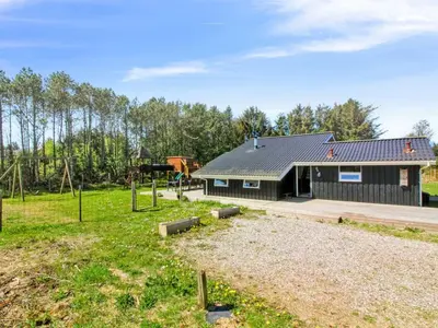 a house with a playground in front of it at Holiday Home Yessica - 300m from the sea by Interhome in Løkken