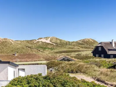 a house on the beach with mountains in the background at Holiday Home Kalervo - 100m from the sea by Interhome in Pandrup