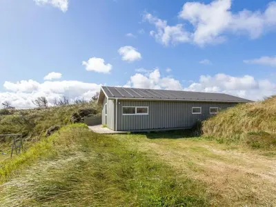 a gray building on the side of a hill at Holiday Home Kalervo - 100m from the sea by Interhome in Pandrup