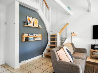 a living room with a chair and a staircase at Holiday Home Ingmarie - 1km from the sea by Interhome in Blokhus