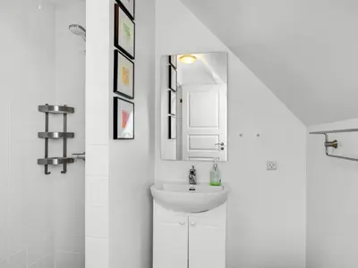a white bathroom with a sink and a mirror at Holiday Home Ingmarie - 1km from the sea by Interhome in Blokhus