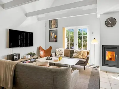 a living room with a couch and a fireplace at Holiday Home Ingmarie - 1km from the sea by Interhome in Blokhus