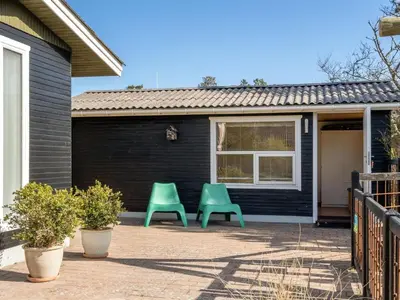 two green chairs sitting outside of a house at Holiday Home Ingebritt - 1-5km from the sea by Interhome in Blokhus