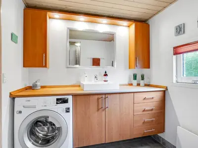 a bathroom with a sink and a washing machine at Holiday Home Vetle - 2-8km from the sea by Interhome in Blokhus