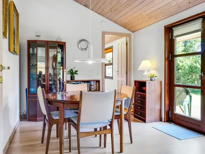 a dining room with a wooden table and chairs at Holiday Home Vetle - 2-8km from the sea by Interhome in Blokhus