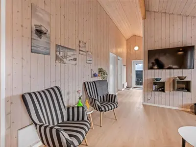 a living room with two chairs and a tv at Holiday Home Elenore - 900m from the sea by Interhome in Løkken