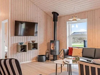 a living room with a couch and a fireplace at Holiday Home Elenore - 900m from the sea by Interhome in Løkken