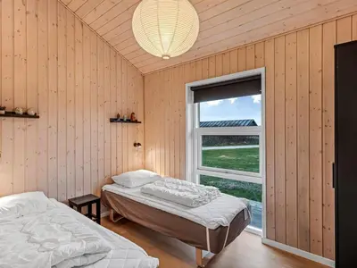 two beds in a room with a window at Holiday Home Elenore - 900m from the sea by Interhome in Løkken