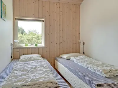 two beds in a room with a window at Holiday Home Felizia - 2-5km from the sea by Interhome in Blokhus