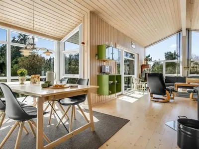 a kitchen and living room with a table and chairs at Holiday Home Felizia - 2-5km from the sea by Interhome in Blokhus