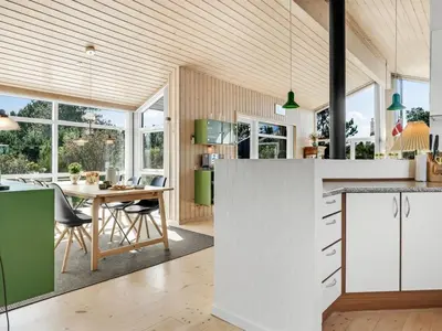 a kitchen with green and white cabinets and a table at Holiday Home Felizia - 2-5km from the sea by Interhome in Blokhus