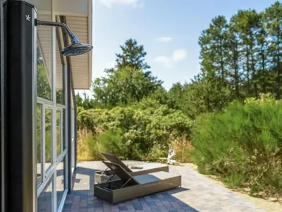 a porch with a lamp and a chair on a patio at Holiday Home Felizia - 2-5km from the sea by Interhome in Blokhus