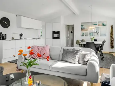 a white living room with a couch and a table at Holiday Home Wiebke - 200m from the sea by Interhome in Blokhus