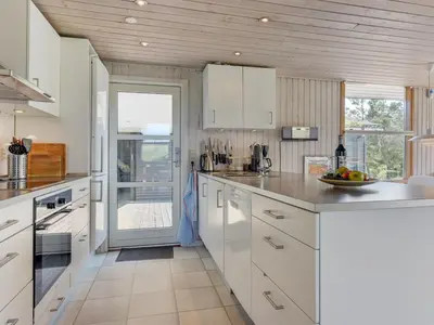 a kitchen with white cabinets and a counter top at Holiday Home Ninna - 1km from the sea by Interhome in Blokhus
