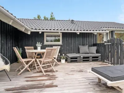 a patio with chairs and a table and a bench at Holiday Home Elayne - 3km from the sea by Interhome in Blokhus