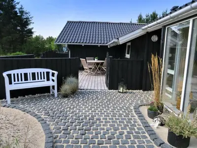 a patio with a white bench and a fence at Holiday Home Elayne - 3km from the sea by Interhome in Blokhus