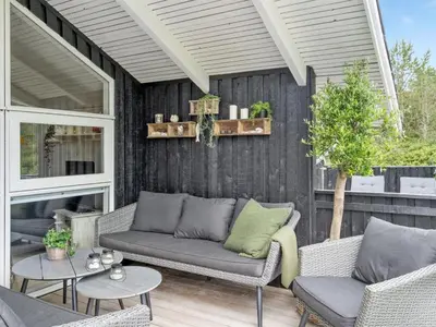 a patio with two couches and a table at Holiday Home Elayne - 3km from the sea by Interhome in Blokhus
