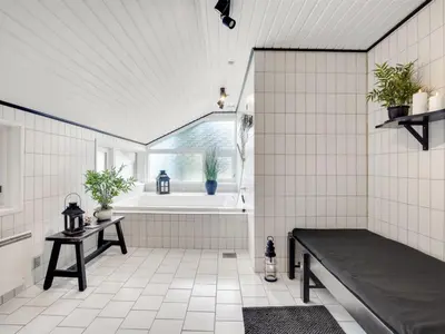 a bathroom with a bench and a bath tub at Holiday Home Elayne - 3km from the sea by Interhome in Blokhus