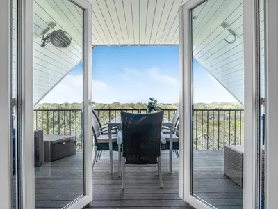 a screened in porch with a table and chairs at Holiday Home Skamhals - 700m from the sea by Interhome in Blokhus