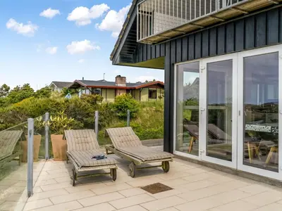 a patio with two chairs and sliding glass doors at Holiday Home Skamhals - 700m from the sea by Interhome in Blokhus