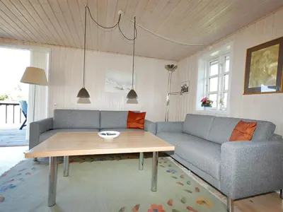 a living room with a couch and a table at Holiday Home Tomke - 1-7km from the sea by Interhome in Blokhus