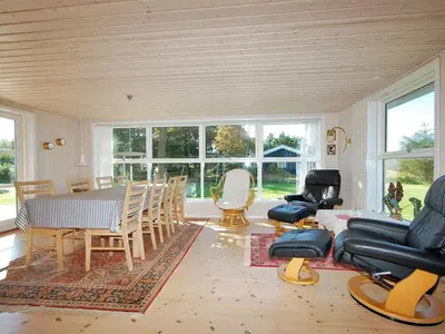 a living room with a dining room table and chairs at Holiday Home Tomke - 1-7km from the sea by Interhome in Blokhus