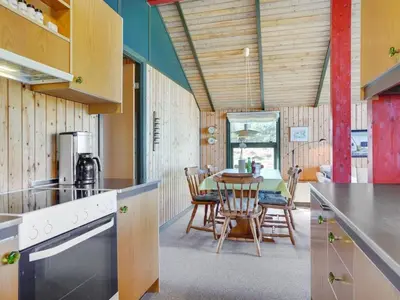 a kitchen and dining room with a table and chairs at Holiday Home Alfrik - 900m from the sea by Interhome in Blokhus