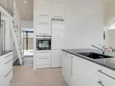 a white kitchen with white cabinets and a sink at Holiday Home Erk - 700m from the sea by Interhome in Blokhus