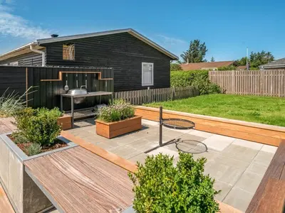 a garden with a patio and a house at Holiday Home Erk - 700m from the sea by Interhome in Blokhus