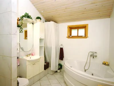 a bathroom with a tub and a sink and a toilet at Holiday Home Tajo - 1km from the sea by Interhome in Blokhus