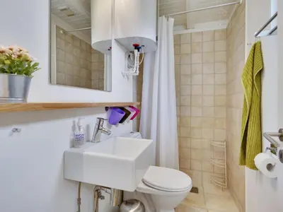 a bathroom with a white sink and a toilet at Holiday Home Bernadeta - 1-2km from the sea by Interhome in Blokhus