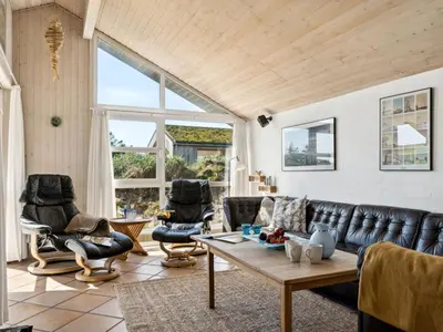 a living room with a leather couch and chairs at Holiday Home Alrune - 800m from the sea by Interhome in Blokhus