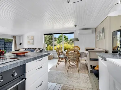 a kitchen and living room with a table and chairs at Holiday Home Noralee - 3-5km from the sea by Interhome in Blokhus