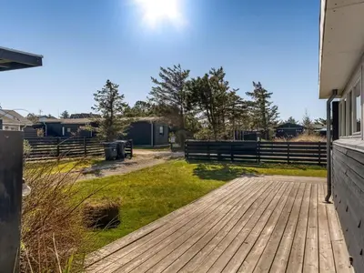 a wooden walkway leading to a yard with a fence at Holiday Home Ozan - 400m from the sea by Interhome in Blokhus