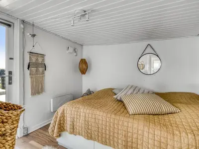 a bedroom with a bed and a mirror on the wall at Holiday Home Ozan - 400m from the sea by Interhome in Blokhus