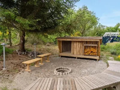 a wooden deck with a bench and a fire pit at Holiday Home Antonina - 800m from the sea by Interhome in Blokhus