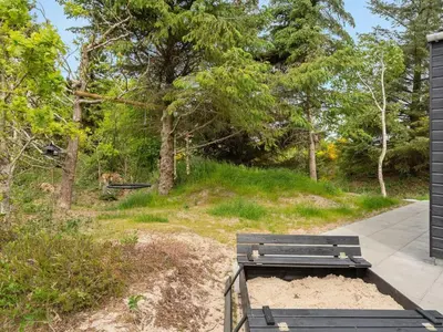 a park bench sitting on the side of a sidewalk at Holiday Home Antonina - 800m from the sea by Interhome in Blokhus