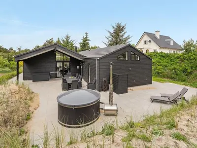 a black house with a gazebo on a patio at Holiday Home Antonina - 800m from the sea by Interhome in Blokhus