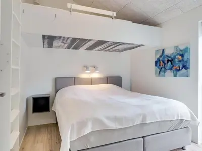 a white bedroom with a bed and a tv at Holiday Home Antonina - 800m from the sea by Interhome in Blokhus