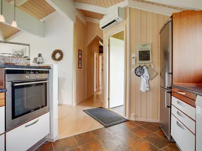 a kitchen with a door leading to a hallway at Holiday Home Friderike - 200m from the sea by Interhome in Blokhus