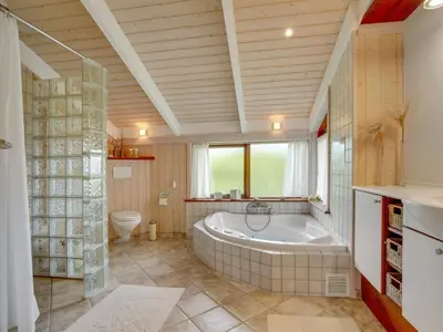 a large bathroom with a tub and a toilet at Holiday Home Friderike - 200m from the sea by Interhome in Blokhus