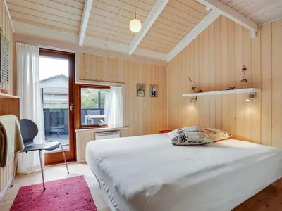 a bedroom with a white bed and a window at Holiday Home Friderike - 200m from the sea by Interhome in Blokhus