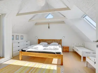 a white bedroom with a bed and a window at Holiday Home Shiva - 300m from the sea by Interhome in Blokhus