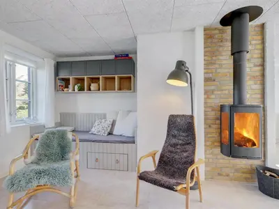 a living room with two chairs and a bed at Holiday Home Shiva - 300m from the sea by Interhome in Blokhus