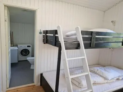 a couple of bunk beds in a room with a bathroom at Holiday Home Ansberga - 1km from the sea by Interhome in Blokhus
