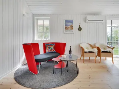 a living room with red chairs and a table at Holiday Home Ansberga - 1km from the sea by Interhome in Blokhus